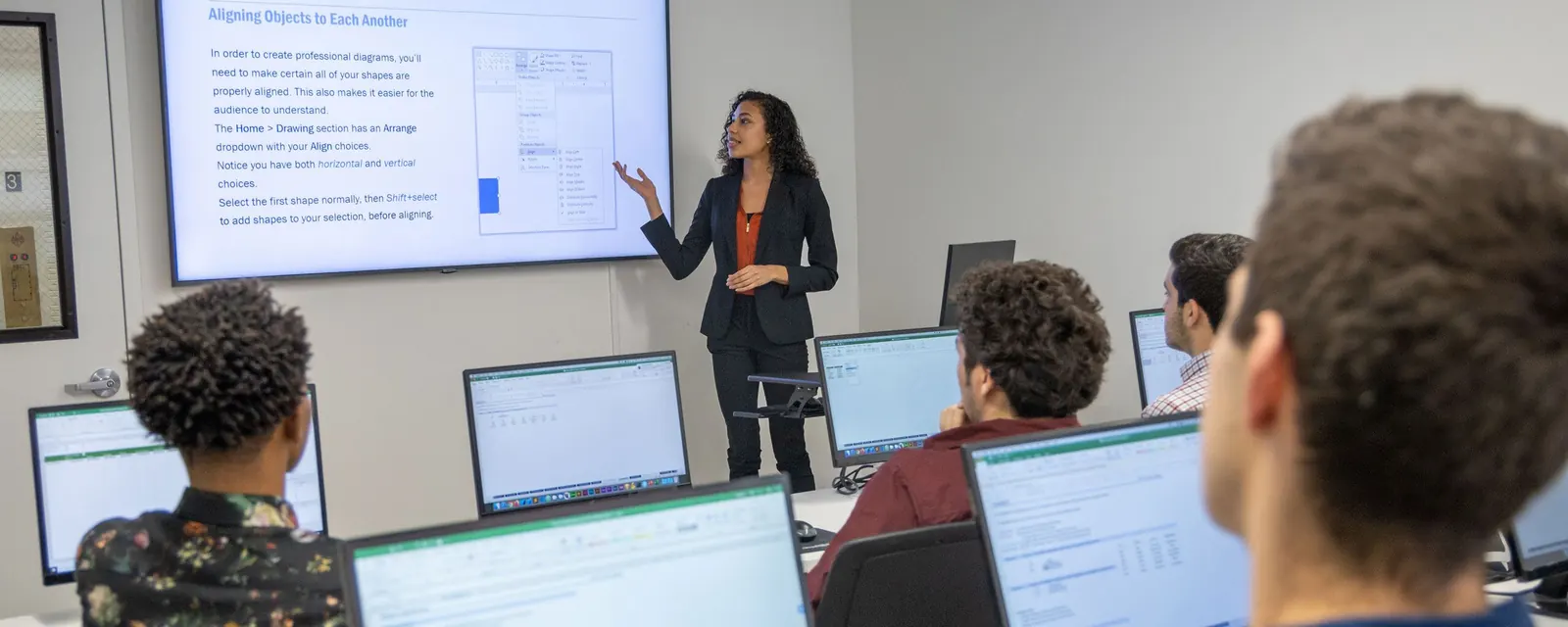 A live training session, an instructor teaching students at workstations